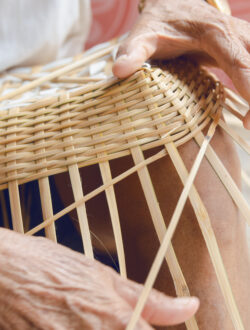 senior man hands manually weaving bamboo.